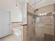 Elegant bathroom featuring a glass-enclosed shower and separate tub, with tiled accents at 2112 Little River Dr, Suwanee, GA 30024
