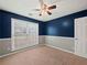 Inviting bedroom with a ceiling fan, neutral carpet, and a large window for natural light at 2112 Little River Dr, Suwanee, GA 30024