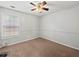 Comfortable bedroom with neutral tones, ceiling fan, carpet, and a large window at 2112 Little River Dr, Suwanee, GA 30024