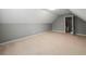 Neutral carpeting covers the upstairs bonus room, which features a closet and door to an unfinished space at 2112 Little River Dr, Suwanee, GA 30024