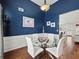 Stylish dining room with wainscoting, hardwood floors, and a modern glass table at 2112 Little River Dr, Suwanee, GA 30024