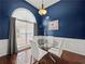 Elegant dining room with dark blue walls, glass table, and ample natural light at 2112 Little River Dr, Suwanee, GA 30024