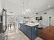Open-concept kitchen with an island and modern lighting connects to the living room and breakfast nook at 2112 Little River Dr, Suwanee, GA 30024