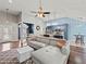 Open concept living room with a large sectional sofa, hardwood floors, and access to the kitchen at 2112 Little River Dr, Suwanee, GA 30024