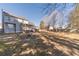 View of the backyard with mature trees, and patio with a firepit at 241 Rockingham Dr, Loganville, GA 30052