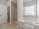 Bright bathroom featuring a garden tub and glass shower at 241 Rockingham Dr, Loganville, GA 30052