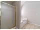 Bright bathroom features a glass door shower and a separate soaking tub at 241 Rockingham Dr, Loganville, GA 30052