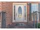 Close-up of a white front door with oval window, brick entryway, and black iron railing at 241 Rockingham Dr, Loganville, GA 30052