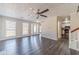 Bright living room with hardwood floors, ceiling fan, and view into the kitchen area at 241 Rockingham Dr, Loganville, GA 30052