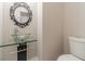 Modern powder room with a glass vessel sink, decorative mirror, and white toilet at 241 Rockingham Dr, Loganville, GA 30052