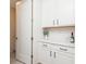 Bright butler pantry featuring white cabinets and countertops with modern hardware at 437 Great Pine Way, Woodstock, GA 30188