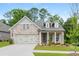 Charming brick home featuring a two-car garage, dormers, and well-manicured lawn at 437 Great Pine Way, Woodstock, GA 30188