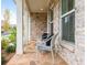 Inviting front porch featuring stone floors, seating, and elegant columns at 437 Great Pine Way, Woodstock, GA 30188