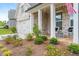 Inviting front porch with elegant columns, stone floor, and professionally landscaped yard at 437 Great Pine Way, Woodstock, GA 30188