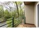 Balcony featuring lush green trees, a green metal railing, and painted stucco walls at 67 25Th Nw St # 5, Atlanta, GA 30309
