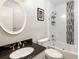 Modern bathroom with black granite countertops, updated faucet, white cabinets, and a tile lined shower and tub combo at 67 25Th Nw St # 5, Atlanta, GA 30309