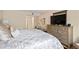 Large bedroom with a wooden dresser, TV, sitting area, and neutral walls with a large window and a decorative piece of art at 67 25Th Nw St # 5, Atlanta, GA 30309