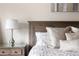 A well-lit bedroom with soft decor, featuring a wooden headboard with white pillows and a lamp on a glass top nightstand at 67 25Th Nw St # 5, Atlanta, GA 30309
