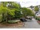 Brookwood Place sign surrounded by manicured hedges, trees, and multiple parked cars at 67 25Th Nw St # 5, Atlanta, GA 30309