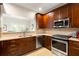 Kitchen with wood cabinets, stainless steel appliances, granite countertops, tile backsplash, and a pass-through to another room at 67 25Th Nw St # 5, Atlanta, GA 30309