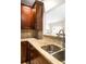 Spacious kitchen featuring wood cabinets, granite countertops, stainless steel sink, and a view into the connected living room at 67 25Th Nw St # 5, Atlanta, GA 30309