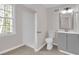 Clean bathroom featuring a shower, toilet, gray vanity, and a well-lit mirror at 1143 Cedar Log, Austell, GA 30168