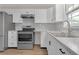 Modern kitchen featuring stainless steel appliances, white cabinets, marble countertops, and hardwood flooring at 1143 Cedar Log, Austell, GA 30168