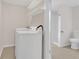 Bright laundry room features tile flooring, shelving, and washer and dryer at 1143 Cedar Log, Austell, GA 30168