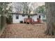 A view of the backyard with a small deck, detached garage, and a yard covered with leaves at 1486 Akridge Nw St, Atlanta, GA 30314