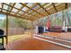 Inviting back deck with a transparent-roofed patio cover, hot tub, grill, and wooded backyard at 226 Double Gate Ct, Sugar Hill, GA 30518