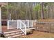 Backyard deck features a hot tub for relaxing, and stairs down to the yard at 226 Double Gate Ct, Sugar Hill, GA 30518