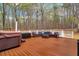 Large deck with outdoor seating and a hot tub overlooking a wooded area at 226 Double Gate Ct, Sugar Hill, GA 30518