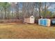 A spacious, fenced backyard features two storage sheds and mature trees at 226 Double Gate Ct, Sugar Hill, GA 30518