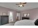 Serene bedroom featuring a ceiling fan, soft lighting, and a view into the ensuite bathroom at 226 Double Gate Ct, Sugar Hill, GA 30518