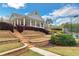 A charming clubhouse featuring elegant architecture, stone steps, and mature landscaping at 226 Double Gate Ct, Sugar Hill, GA 30518