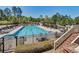 Community pool featuring a covered outdoor lounge area, tables with chairs, and a gated pool perimeter at 226 Double Gate Ct, Sugar Hill, GA 30518