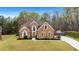 Charming brick home featuring a well-manicured lawn and a long concrete driveway at 226 Double Gate Ct, Sugar Hill, GA 30518