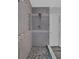 Modern shower with gray tile, pebble floor, and glass door at 226 Double Gate Ct, Sugar Hill, GA 30518