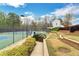 Community tennis court with lush landscaping, bordered by hedges and trees, offering a serene environment at 226 Double Gate Ct, Sugar Hill, GA 30518