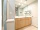 Bright bathroom featuring double sinks with oak cabinetry and large framed mirror with vanity lighting at 225 E Ponce De Leon Ave # 317, Decatur, GA 30030