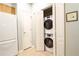 Interior laundry area with stacked washer/dryer and tiled floors, adjacent to a full-sized refrigerator at 225 E Ponce De Leon Ave # 317, Decatur, GA 30030