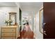 Bright condo hallway with hardwood floors leading to the open kitchen area and featuring a decorative mirror and chest at 3300 Windy Ridge Se Pkwy # 612, Atlanta, GA 30339