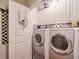 Clean and functional laundry room with white cabinets, stainless steel appliances, and unique decorative mirror at 3300 Windy Ridge Se Pkwy # 612, Atlanta, GA 30339