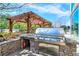 Outdoor grill featuring stone surround, stainless steel grill, pergola, and concrete patio at 3300 Windy Ridge Se Pkwy # 612, Atlanta, GA 30339