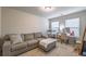 Comfortable bedroom with a gray couch, a vanity area, and two windows letting in natural light at 2461 Bayrose Cir, Atlanta, GA 30344
