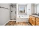 Bright bathroom featuring a tub, separate shower, double sinks, and wood look floors at 3227 Grove Trl, Acworth, GA 30101