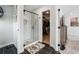 Modern bathroom featuring a glass-enclosed shower, dark tile flooring, and access to a walk-in closet at 3628 Silvery Way, Powder Springs, GA 30127