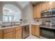 Galley kitchen featuring stainless steel appliances, wood cabinets, and plenty of natural light at 375 Highland Ne Ave # 903, Atlanta, GA 30312