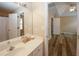 Bathroom view shows a white vanity and mirror, wood-look floors, and access to a bedroom at 5364 Hickory Knl, Norcross, GA 30071