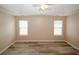 An empty bedroom with two windows, wood floors, ceiling fan and neutral paint at 5364 Hickory Knl, Norcross, GA 30071